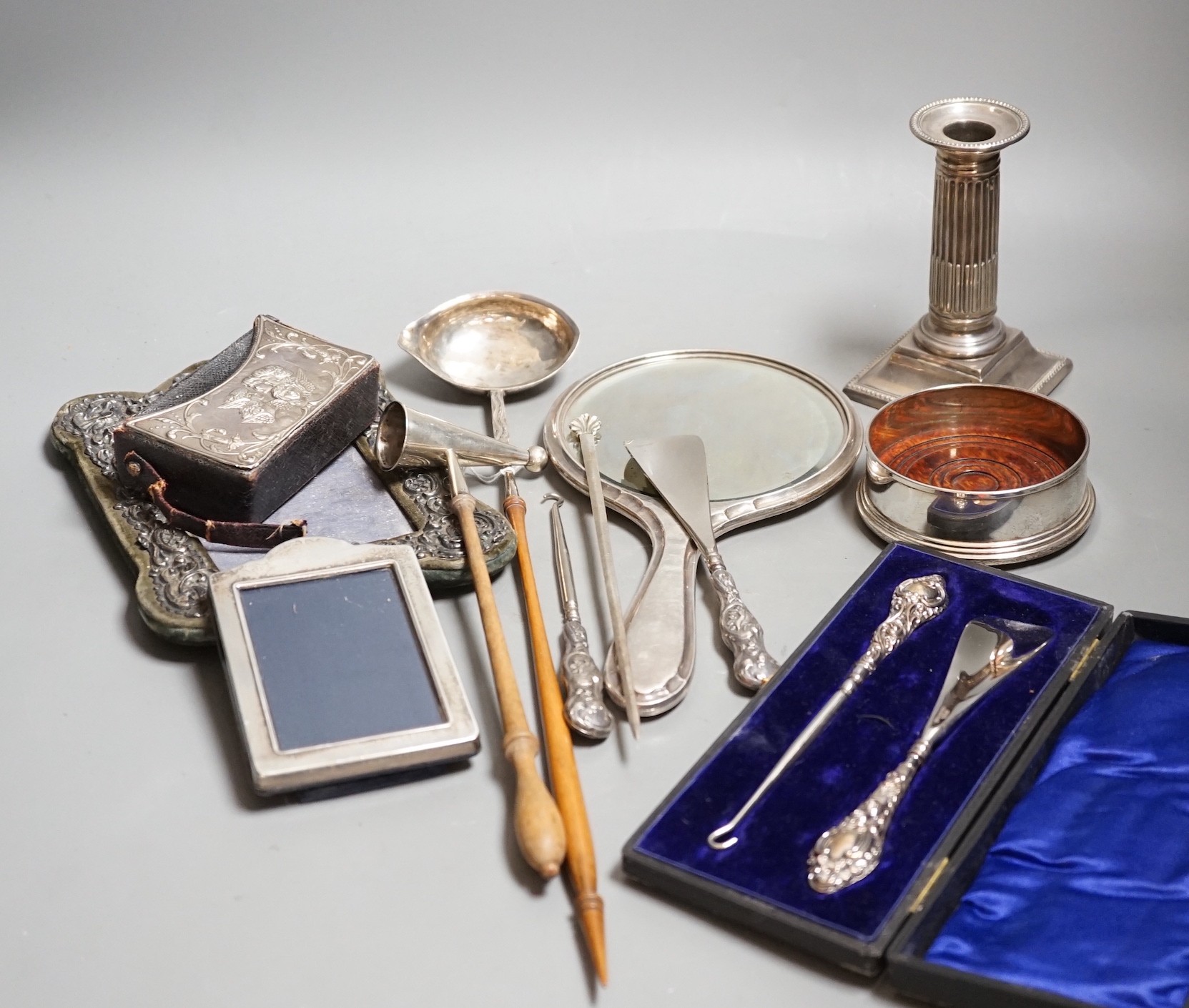 A group of small silver including two mounted photograph frames, one Birmingham, 1901, a mounted bible case, candlestick snuffer, coaster, etc.